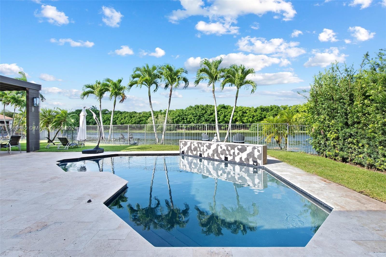 Discover the epitome of upscale living at prestigious Weston Hills. This stunning 4-bedroom, 3-bath home features a modern kitchen, wood floors throughout, and a picturesque lake view, creating a serene ambiance. Entertain with ease using the summer kitchen and relax by the pool with a captivating waterfall. The property also includes an office space (5th bedroom), perfect for remote work or study. Plus, take advantage of access to A-rated schools, making this the ideal home for families. Don't miss the opportunity to experience luxury living in this exquisite lakeside retreat!