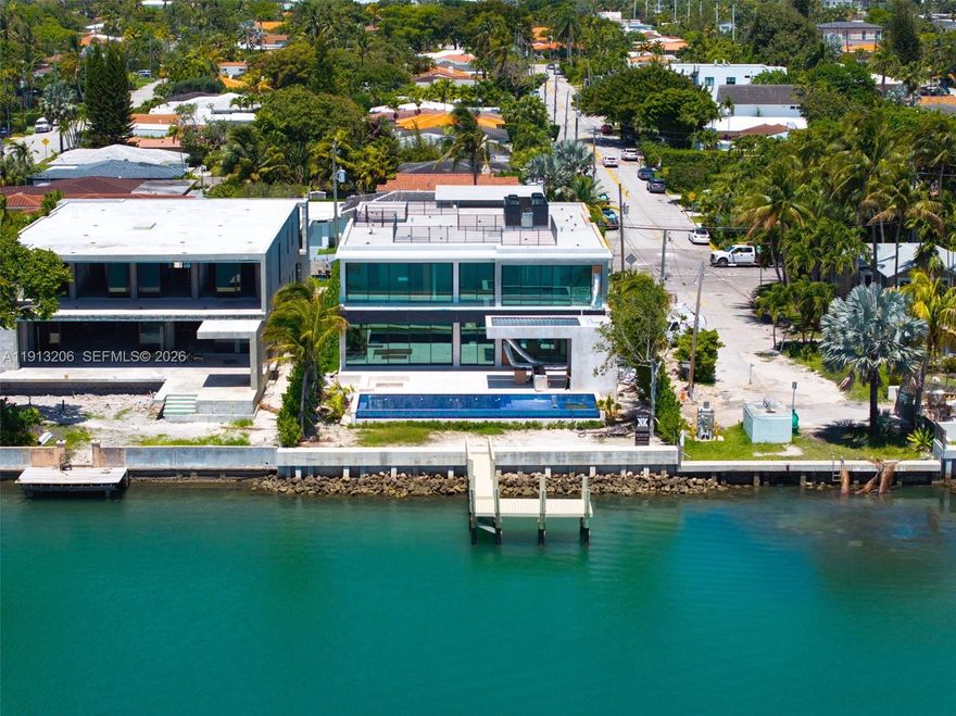 Brand new modern waterfront masterpiece in Surfside! Set on a rare corner lot showcasing 9,900 SF under A/C, this architectural masterpiece by Kobi Karp redefines modern elegance. Designed for seamless indoor/outdoor living with 75 ft of direct south facing frontage with no fixed bridges, sunset views, & walkability to the beach, places of worship, & top dining. The 1st level features Italian kitchen cabinetry & millwork, a junior primary suite, office, chef’s kitchen, cabana, & generous living areas. Upstairs, a dramatic primary suite showcases panoramic water views. Additional spacious bedrooms, a water facing pajama lounge with large private terrace, and gym with sauna/steam offer luxury living at its finest. Smart home technology & marble finishes elevate every detail. Crafted for those who expect nothing less than exceptional. Delivering Early 2026.