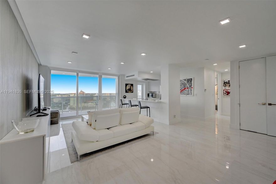 This impeccably renovated one-bedroom, one-bath penthouse offers a sophisticated living experience with premium finishes and thoughtful design throughout. Featuring elegant marble surfaces on floors and walls, complemented by marble kitchen and bath countertops, this residence exudes timeless elegance. Custom built-in furnishings and impact-resistant sliding glass doors and windows enhance both functionality and style.
The open floor plan is accentuated by recessed ambient lighting, while vaulted ceilings create an airy, expansive feel. Recent updates include fresh interior paint and a complete stainless steel appliance package. Residents enjoy access to an exceptional array of building amenities, making this an outstanding choice for discerning buyers. Priced to move, schedule your private showing today before this exceptional opportunity is gone.