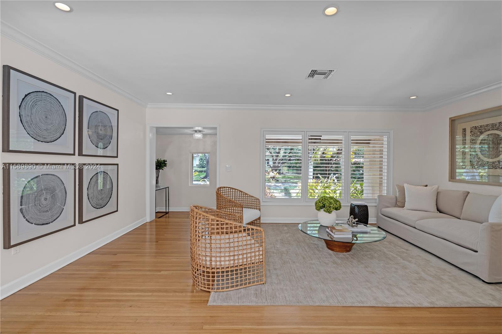 Located on a lovely tree lined street, this home invites you to enjoy a blend of formality and functionality. Formal foyer entry, large living and dining rooms with views of the pool and patio. Beautifully finished hardwood floors throughout the living areas and bedrooms. Well-designed open kitchen with granite counters, white wood cabinetry, and kitchen Aid appliances opens to the oversized family room with access to the pool and terrace. Each of the spacious bedrooms offers beautifully built-out closets. The primary bedroom has two large built-out closets, updated bathroom and shower. A second bedroom has newly updated bath-en-suite. New roof, insulated & air-conditioned 2 car garage, impact windows & doors and security system all enhance this very special Coral Gables home.