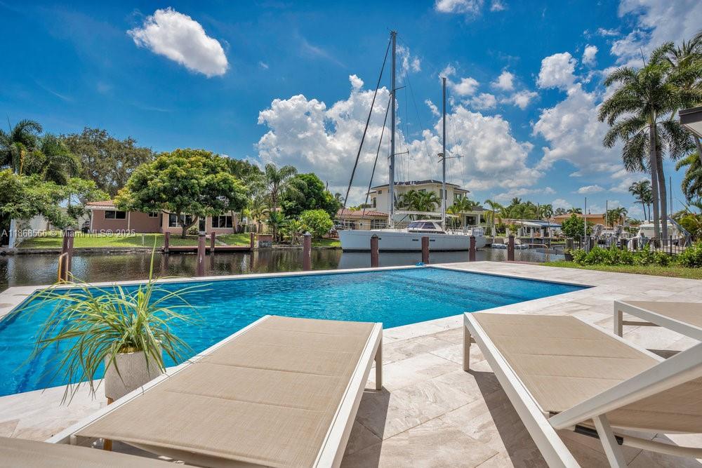 Welcome to 1004 Guava Isle, a fully reimagined waterfront home with 75 ft of frontage, private dock, brand-new pool + deck, and no fixed bridges to the ocean. This Home was completely gutted and rebuilt with permits: new metal roof, plumbing, electrical, impact windows/doors, flooring, designer kitchen + baths, and custom closets. The sunlit open concept integrates kitchen, dining, and living areas with seamless views of the canal, pool, and your boat. Extra room doubles as family room, office, or 4th bedroom. Secure fencing completes this turnkey property. This is the one — move-in ready for modern waterfront living.