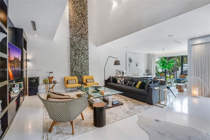 Life at l'Hermitage feels like a private resort on the shores of Biscayne Bay in the North Grove. This tri-level villa overlooks the pool and has 6 spacious bedrooms. It has been meticulously renovated in 2012-13 down to the studs -with permits and features an additional 315 Sqf integrated into the floor plan: Smart Home, Mia Cucina kitchen, Wolf & Miele appliances. This home overlooks the swimming pool with double height ceilings. This villa includes a private 35-foot boat slip, perfect for spontaneous getaways on the ocean, along with access to two tennis courts designed for the avid player who enjoys an active lifestyle.  With 24/7 gated security, lush landscaping in a prime location, l'Hermitage offers the ultimate blend of privacy, security, luxury and marina-style living.