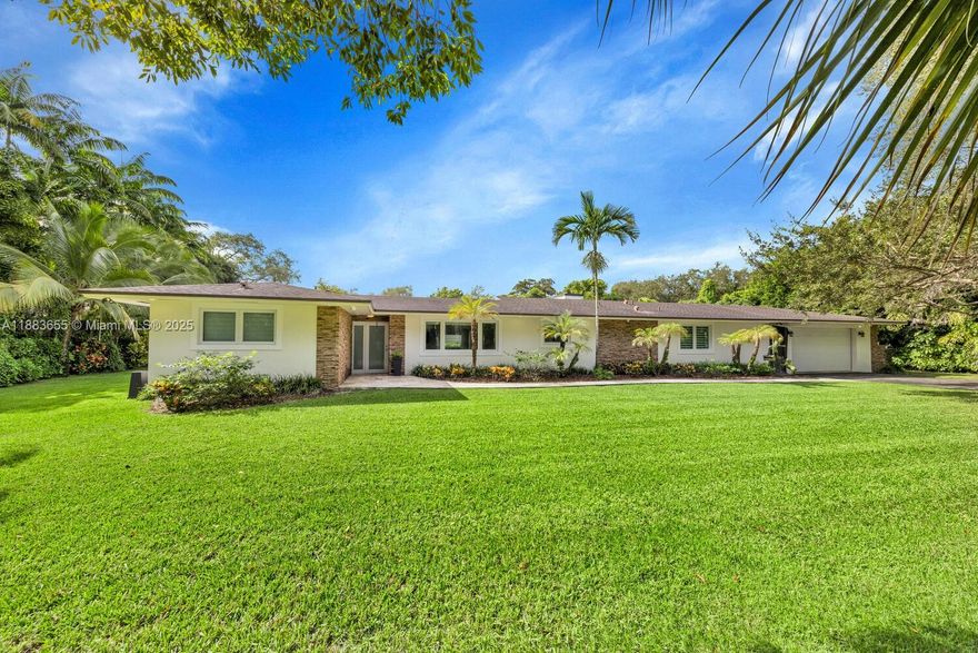 Sitting on over 50,000 SF of land, this 4BD/2BA residence presents a unique combination of comfort, character & future potential. The home is equipped with hurricane impact windows, wood look tile floors throughout, Thermador kitchen appliances, an original fireplace that adds timeless charm & a convenient pass through 2 car garage. The thoughtfully designed split floor plan offers a private primary suite separated from the other 3 bedrooms. Enjoy this home in its current condition, live in it while you plan & design your dream estate, or as a builder, rent it out while preparing your future project with plans & permits. This rare property provides endless opportunities for families, investors & developers alike, all within an exceptional setting that combines land, location & lifestyle.