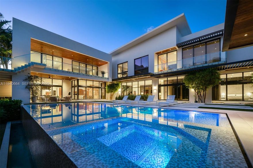 Designed by renowned architect Alberto Cordovez, this extraordinary Ponce Davis estate delivers nearly 10,000 SF under air on an expansive 45,302 SF lot. Featuring 7 bedrooms, 8 full baths, and 1 half bath, the residence blends striking modern architecture with resort-style living. A private gated drive leads to an oversized driveway and a 3-car garage with space for 3 additional car lifts, surrounded by lush tropical landscaping featuring bamboo and foxtail trees. Interiors showcase soaring ceilings, limestone and hardwood floors, fluted walls, integrated architectural ceiling system, custom Italian doors, elevator, Crestron automation, private movie theater, full gym, and multiple family and entertaining spaces—all bedrooms overlooking the pool. The chef’s Mia Cucina kitchen is equipped with Wolf and Sub-Zero appliances, double ovens, steam oven, wine room, and oversized island. Outdoors, enjoy covered terraces, summer kitchen, cabana, and a 20’ x 40’ saltwater infinity pool with spa and waterfall. A full-house generator, a full house water filtration system, advanced security, and premium systems complete this one-of-a-kind modern retreat.