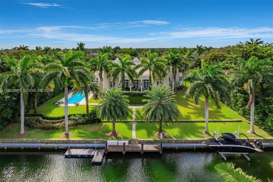 Spectacular waterfront estate in the exclusive, guard-gated community of Gables Estates, offering 9,236 SF under air  and 12,102 total, on beautifully landscaped grounds. With 6 bedrooms, 6 full baths, and 2 half baths, this residence blends timeless Dutch and Island-inspired architecture with refined luxury. Designed with distinct east and west wings, the home features double-height ceilings, an elegant Connemara marble staircase, marble and wood floors, and grand living and formal dining rooms. The chef’s kitchen is equipped with Gaggenau appliances, Sub-Zero refrigeration, custom cabinetry, and a spacious island with seating, opening to a bright breakfast area and family room. Additional highlights include a library with custom millwork, two fireplaces, elevator, and advanced home systems. The private main suite offers a serene retreat with terrace access, dual walk-in closets, and a luxurious marble bath featuring a long mirrored vanity, Jacuzzi, and multi-jet shower. Outdoors, enjoy 180 feet of waterfront with a 20,000 lb boat lift and direct, no-bridge access to Biscayne Bay. Covered terraces overlook the pool and manicured gardens, complemented by a 4-car garage and expansive driveway—an exceptional waterfront offering where elegance meets effortless coastal living.