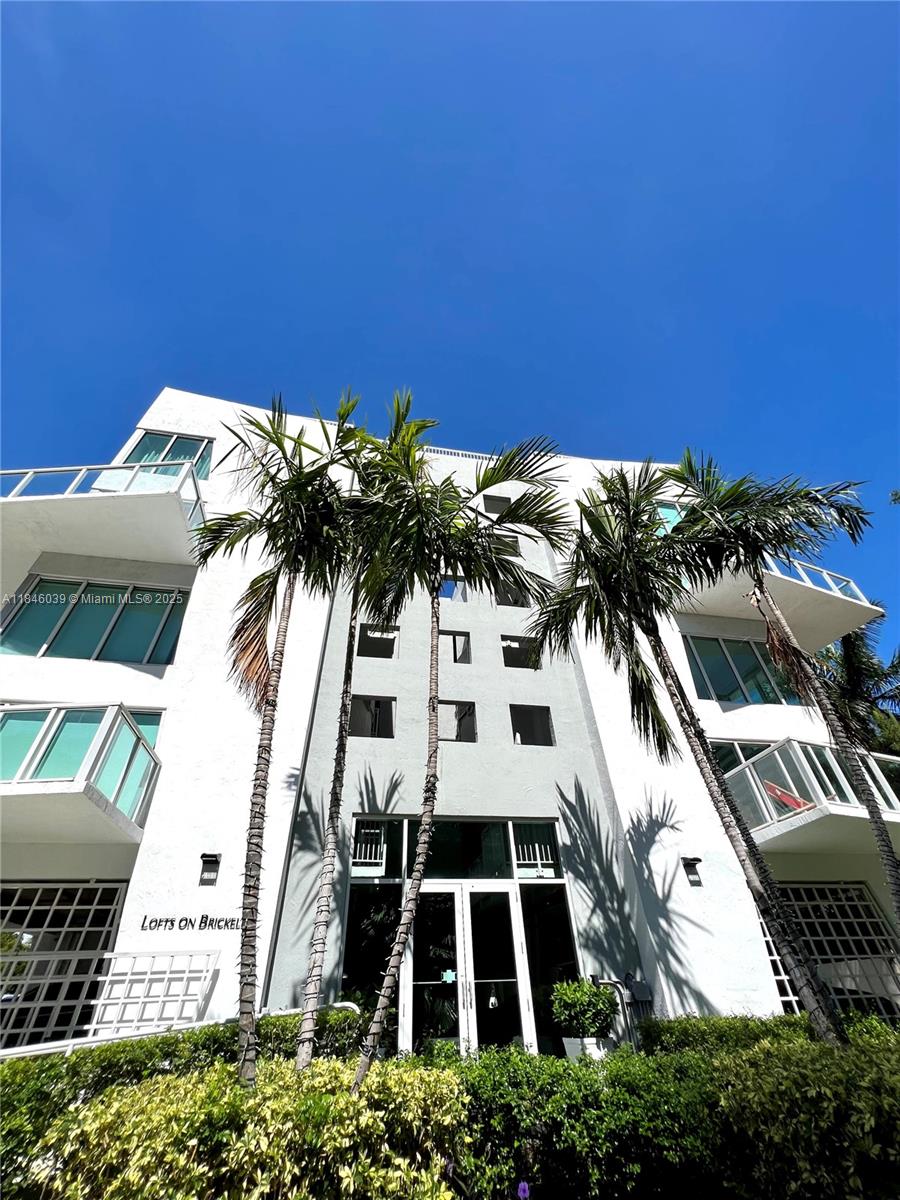 Stylish two-story loft in the heart of Brickell—just steps from the action, yet tucked away for privacy and peace. This impeccably maintained residence features wood flooring throughout, soaring double-height ceilings, and floor-to-ceiling windows that flood the space with natural light. The first floor offers an open-concept kitchen with stainless steel appliances, washer/dryer, and a renovated powder room. Upstairs, enjoy a spacious master suite with a finished walk-in closet and updated bathroom. Large balconies on both levels provide open views of lush gardens and iconic Brickell Avenue. New A/C. Prime location near top restaurants, shops, and transit. No pets allowed by HOA, except service animals with proper documentation.