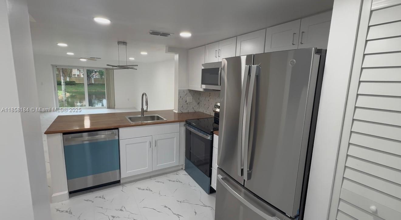 FULLY RENOVATED 3-BEDROOM, 2-BATHROOM TOWNHOUSE IN SUNRISE!. Located in a community with a pool. This home features a brand-new kitchen with clear cabinets and high-end stain appliances. Both bathrooms have been completely remodeled with a modern and bright design. All windows are hurricane-impact. Brand-new A/C unit and water heater. The open and split floor plan offers abundant natural light.