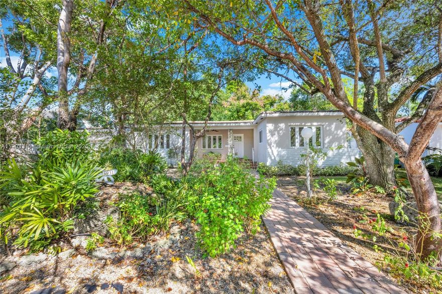 Welcome to this charming 3-bedroom, 2-bathroom Biltmore Heights home with hardwood floors throughout living areas and bedrooms. The spacious sun-drenched family room features wall-to-wall windows, open beam ceiling and tile flooring, while the inviting front porch offers beautiful Southern exposure surrounded by mature shade trees. Inside, discover an updated kitchen w/skylight and formal dining room. Authentic 1950s vintage touches include original bathroom tiles and classic Dade County pine wainscoting in one bedroom. Impact windows and doors provide hurricane protection and quiet. The converted garage offers versatile workspace and laundry area, perfect for home office or studio (the SF of the converted garage is NOT included in the living area total). One of Miami's best neighborhoods!