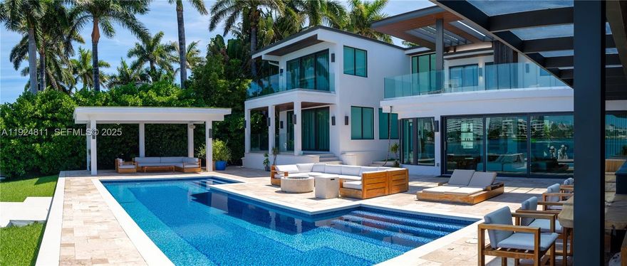 This stunning waterfront sanctuary on the prestigious Venetian Islands offers 90 feet of prime bay frontage, seamlessly blending serene privacy with the vibrant energy of Miami Beach. Set on a rare lot-and-a-half, this architectural gem is designed for the discerning art lover and entertainer alike. Inside, soaring ceilings and walls of glass flood the home with natural light, framing sweeping open bay views from nearly every room. The expansive floor plan connects effortlessly to outdoor living areas, where a custom summer kitchen, Brazilian-style BBQ and pizza oven, and sparkling private pool await. Host unforgettable gatherings poolside or unwind under the stars in the elegant lounge areas with gas fire features. A newly designed chef’s kitchen, marble floors, and gallery-style walls enhance the home’s sophisticated yet relaxed ambiance. The property includes 6 bedrooms, 6.5 baths, a custom 4-car garage, and breathtaking view of blue oceans and this wonderful city. A true Miami masterpiece, this is waterfront living elevated. Minutes from Sunset Harbor, the Design District, world-class shopping, dining, and culture. Originally built in 1939, but fully remodeled with permits in 2015. Effective year built per Property Appraiser is 2015.