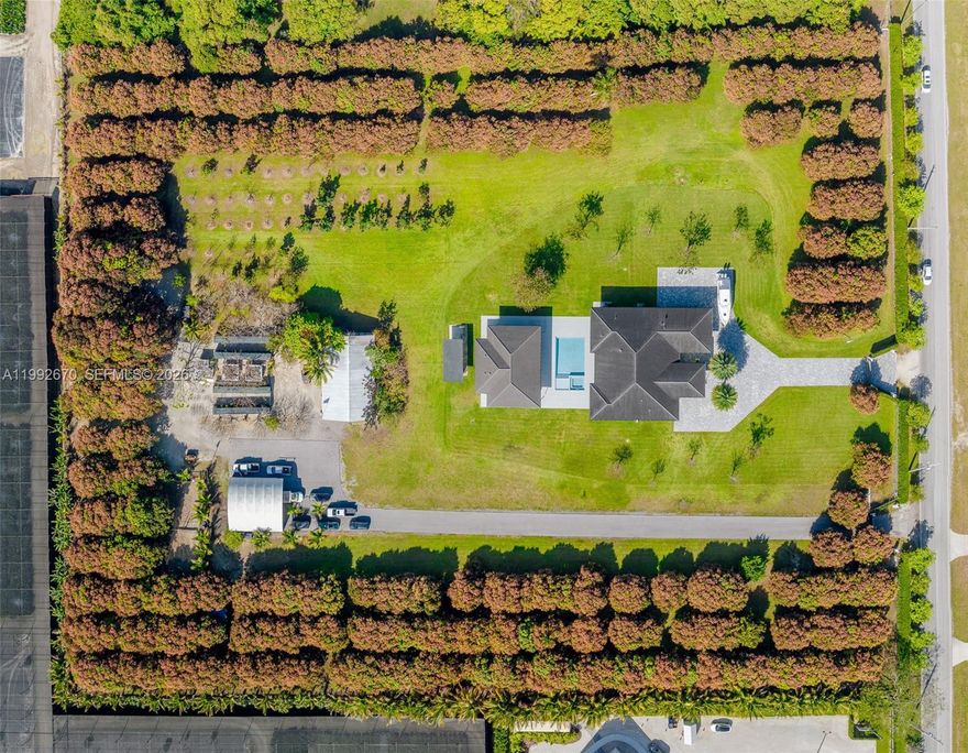 Welcome to Hacienda Moderna - a rare offering that blends 21st-century luxury with expansive countryside living. Set on 7.5 acres, this exceptional estate features an income-producing mango grove with over 300 trees, complemented by a diverse collection of fruit trees including avocado, mamey, lime, tamarind, soursop, sugar apple, plum, banana, & coconut. Here, you can truly disconnect & immerse yourself in the beauty & tranquility of nature. At the heart of the property lies a stunning contemporary one-story home built in 2021. With 4 bedrooms & 5 full baths, the home offers an ideal floor plan w/ formal living & dining rms, spacious open-concept family rm, luxurious private master suite, & state-of-the-art kitchen. Additional highlights include high ceilings, elegant porcelain tile flooring, full impact windows/doors & 2-car garage. Designed for exceptional outdoor living & entertaining, the property features a large pool & jacuzzi + an impressive 2,400 sq ft covered terrace w/ summer kitchen including grill, burner, refrigerator, icemaker, dishwasher, & cabana bath. The estate is fully secured, accessed through electric gates that open to a long brick driveway & porte-cochère + separate service entrance. The expansive grounds offer endless opportunities for agricultural, farming, or landscaping pursuits. Ideally located just west of Krome Avenue, Hacienda Moderna offers convenient access to local nurseries, fruit stands, and the best of South Miami-Dade attractions.