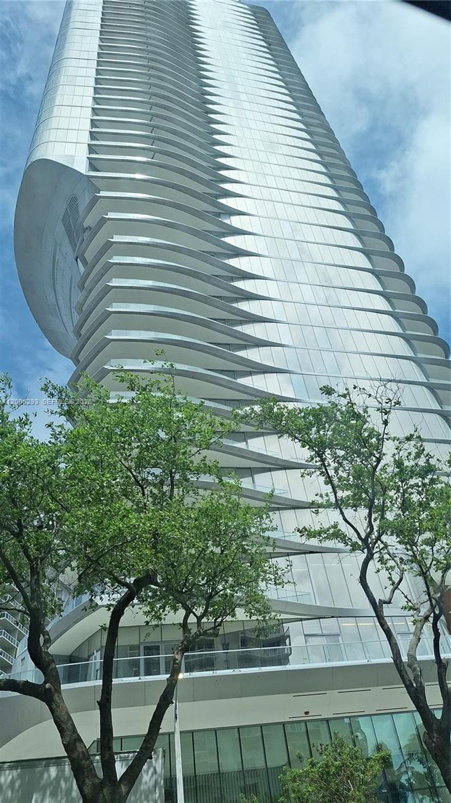 Architectural Design and Inspiration
Una Residences, developed by OKO Group and Cain International, takes inspiration from classic yacht design, featuring sweeping curves and a reflective glass façade that maximizes natural light and Biscayne Bay views. The building is instantly recognizable for its dramatic silhouette, which combines elegance with modern architectural innovation. These awesome 3-bedrooms and 3-1/2 Bathrooms. Unit has sophisticated high-end finishes, floor-to-ceiling glass windows, and expansive terraces providing unobstructed water and city skyline views. Ceiling heights up to 10'8", Private elevator entry, Chef’s kitchens equipped with Gaggenau ovens, induction cooktops, dishwashers, and full-sized refrigerators/freezers. Valet parking, full-time residence manager on-site, and staff committed to excellence.