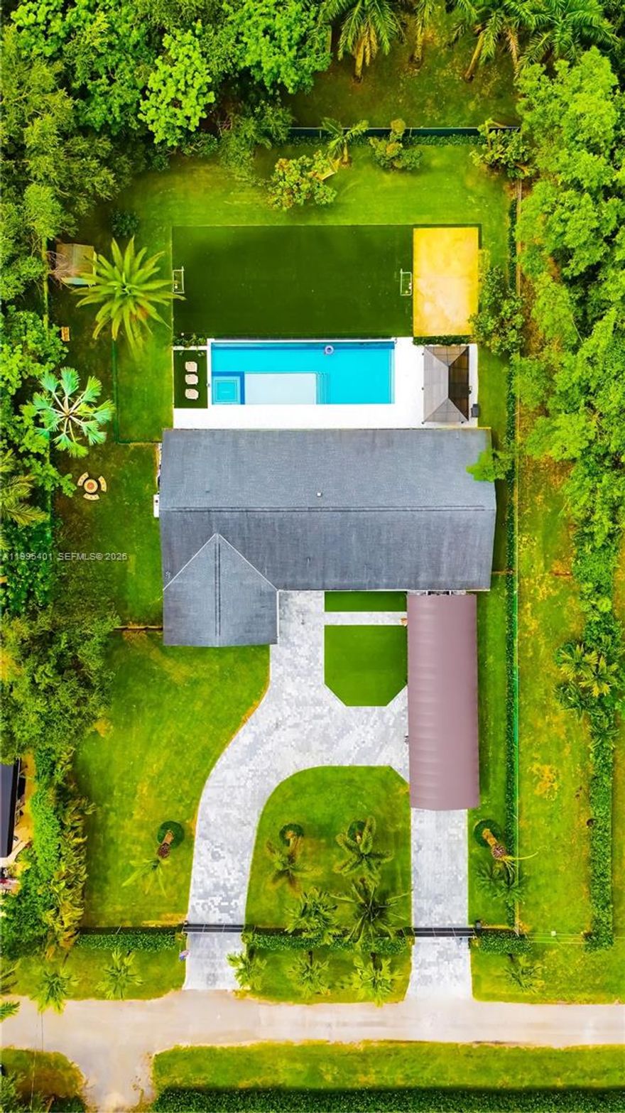 The house features bathrooms and a kitchen that were completely remodeled in 2024. Also added in 2024 was a 50-foot by 18-foot infinity-edge pool, equipped with a heater, a saltwater system, and full automation. The property boasts a synthetic-turf soccer field and a sandy beach volleyball area. The lot spans nearly an acre and is divided by a fence into two sections—each with its own independent entrance—making the undeveloped portion ideal for a business venture or for building a guest house. The driveway features a covered canopy tall enough to shelter a boat or an RV. The home is served by well water and includes a two-car garage. Currently, the property operates as an Airbnb rental; it comes fully furnished and equipped, allowing a new owner to seamlessly continue the business—a process currently managed by a dedicated administrator. The entire operational infrastructure is already in place to ensure the business continues without interruption; we can provide Airbnb financial statements so prospective buyers can review the revenue figures. The roof and air conditioning system were already installed when we purchased the property in 2021, though they were relatively new at the time. This residence offers spacious interior and exterior living areas, featuring beautiful garden spaces with tremendous potential for a wide variety of uses.