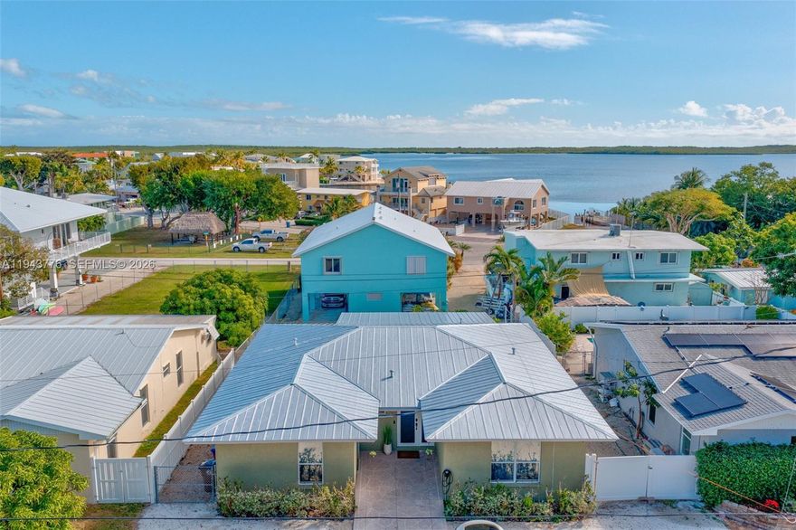 * CBS 4/2 CONCRETE HOME WITH A BRAND NEW METAL ROOF! * OPTIONAL HOMEOWNERS PARK WITH BOAT RAMP * Your Keys paradise is found in this inviting 4-bedroom, 2-bath, 2,283 sq. ft. home in Largo Sound Village, one of north Key Largo's most desirable neighborhoods. Great location near the neighborhood boat ramp with peek-a-boo views of the water! Inside, you'll find a beautifully updated kitchen featuring white cabinetry, Silestone countertops, stainless appliances and barstool counter seating. The spacious living room and large, fully enclosed all season room provide abundant space for entertaining or relaxing.  Large windows bring in lovely natural light throughout. Four bedrooms and two well-appointed bathrooms ensure space and comfort for the entire family. The primary bedroom offers a luxurious ensuite bathroom with a large walk-in shower. One bedroom has an exterior door, offering the option to create a separate in-law suite. Optional PRIVATE homeowner's park with a BOAT RAMP, tiki hut and trailer parking for ONLY $150 PER YEAR! Quick access to the ocean or bay. Situated on a generous 6,000 sq. ft. lot, there is plenty of parking for vehicles, boat trailers, or an RV. A 240V Tesla Fast Charger makes this home turnkey for electric vehicle owners. Built with durable CBS concrete construction and a new metal roof, this home offers peace of mind and lasting quality.  Just an hour's drive from Miami makes this home your ideal Florida Keys getaway.