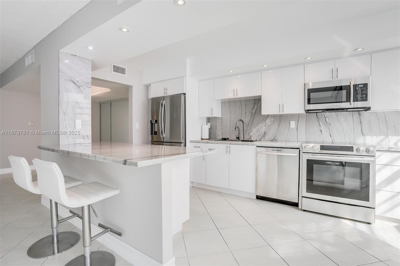 Welcome to modern luxury in this expansive 2-bedroom, 2-bathroom high-rise condo, offering 1,565 square feet of sophisticated living space. The kitchen boasts stunning quartzite counters, while the bathrooms feature elegant quartz finishes. Enjoy the convenience of motorized shades, a Nest thermostat, and a brand-new AC unit for optimal comfort. This waterfront residence includes premium amenities such as a guarded gate, elevator, newly renovated gym, and spa. Additional features include a restaurant, barbecue area, common media/recreation room, billiards room, tennis court, and laundry facilities. With assigned and guest parking, a bike room, and a common boat ramp, this condo provides everything you need for a modern lifestyle.