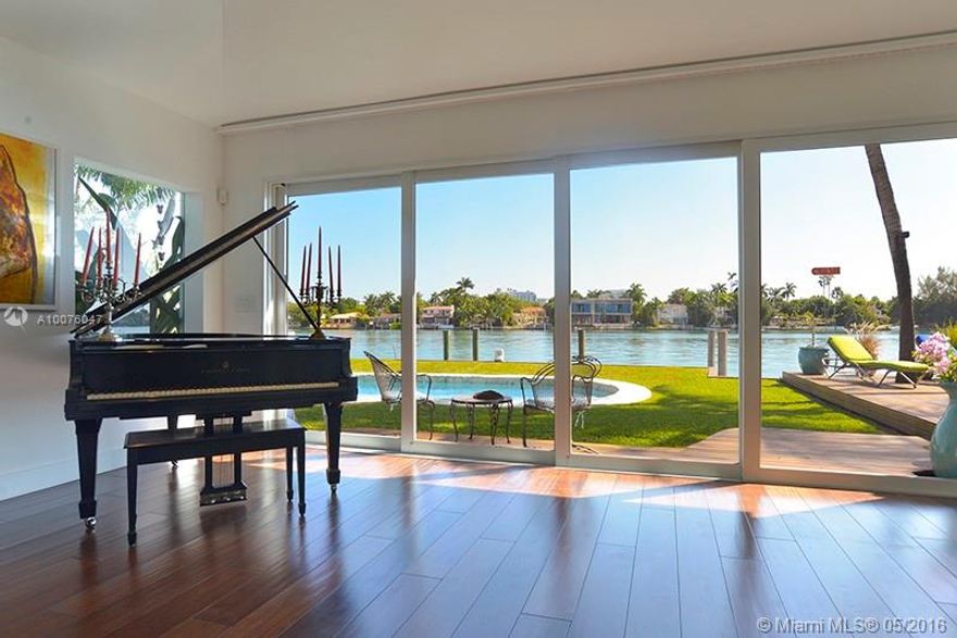 Rebuilt in 2010 this stunning tropical modern home features three bedrooms, three and 1/2 bathrooms. Highlights include European chef kitchen, open plan living and dining, lofted ceilings throughout, 8" wide Brazilian walnut wood floors, Lutron lighting, showcase glass door garage with lifts to accommodate four cars. Coveted SE corner exposure to cool breezes during the summer months and protection from NW storms in winter months. Spacious rear yard with entertainment deck and 105 feet wide bay views.