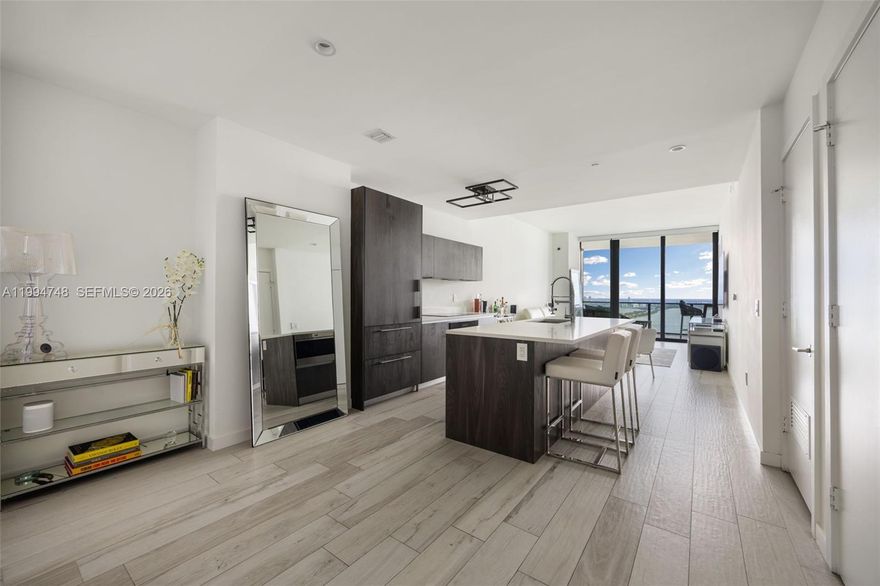 A refined waterfront residence in the coveted “04” line at Gran Paraiso, offering sweeping panoramic bay and ocean views from an elevated vantage point in the heart of Edgewater. This 2-bedroom, 3-bathroom showcases 10-foot ceilings and expansive living spaces filled with natural light, seamlessly extending to an oversized balcony with stunning views of the Miami Beach skyline. Elegant, modern interiors are finished with porcelain flooring throughout, custom Italian Italkraft cabinetry, quartz countertops, and a premium suite of Sub-Zero and Wolf appliances. A private elevator opens directly into the residence’s foyer, creating a heightened sense of privacy and arrival, complemented by built-in walk-in closets and refined window treatments. Set within the iconic Gran Paraiso tower by Arquitectonica, residents enjoy an exceptional collection of resort-style amenities including a waterfront pool, spa, state-of-the-art fitness center, tennis courts, bowling alley, theater, wine room, and more, all moments from Midtown, Wynwood, the Design District, Miami Beach, and Downtown.