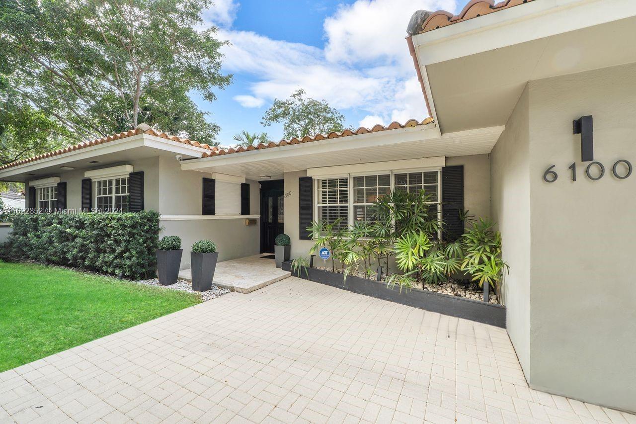 A perfect blend of traditional and modern on a quiet street in South Gables. This 3-bedroom, 3-bathroom home has a partially open layout and sensible flow for convenient and comfortable living. Enjoy views of the sparkling pool from a spacious and sun-filled living room. The warm dining room with a beautiful chair-rail molding is perfect for cozy dinners, and the eat-in kitchen has custom cabinetry, granite solid surface countertops, white Carrara marble center island with storage, and LG appliances. Expand family living outdoors to a covered terrace perfect for relaxing and entertaining. The brick driveway leads to a 2-car garage with storm-grade door, epoxy flooring, grid and rack system, and EV charger.