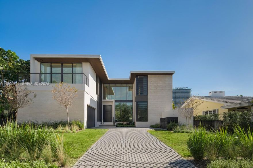 Set within the gated Village of Bal Harbour,one of Miami’s most exclusive enclaves,this newly completed residence exemplifies modern design and refined craftsmanship.Created by Sire Design,the six bedroom,six and a half bath smart home features a mix of green onyx,Arabescato Rosso marble,black stained oak,and piano lacquer finishes. Each space is curated with custom furnishings and sculptural lighting for a warm contemporary aesthetic.The Mia Cucina kitchen with Miele appliances anchors the main level,while the primary suite offers dual dressing rooms,a spa inspired bath, and private sauna.A dramatic staircase with floating chandelier serves as a striking centerpiece. Outside,a resort style terrace offers a pool,spa,and summer kitchen,creating a private retreat in the heart of Bal Harbour.