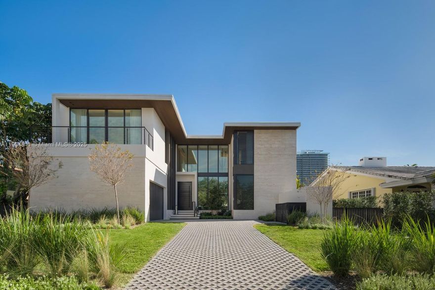 Set within the gated Village of Bal Harbour,one of Miami’s most exclusive enclaves,this newly completed residence exemplifies modern design and refined craftsmanship.Created by Sire Design,the six bedroom,six and a half bath smart home features a mix of green onyx,Arabescato Rosso marble,black stained oak,and piano lacquer finishes. Each space is curated with custom furnishings and sculptural lighting for a warm contemporary aesthetic.The Mia Cucina kitchen with Miele appliances anchors the main level,while the primary suite offers dual dressing rooms,a spa inspired bath, and private sauna.A dramatic staircase with floating chandelier serves as a striking centerpiece. Outside,a resort style terrace offers a pool,spa,and summer kitchen,creating a private retreat in the heart of Bal Harbour.