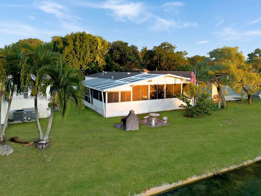 Experience waterfront living in this spacious home located in the established, gated community of Gateway Estates. This property offers a rare direct lakefront position, providing a peaceful backdrop and serene water views. The front of the home is shaded by a magnificent ficus tree, creating a cool and inviting entrance that leads to a charming screened front porch and a convenient storage shed. Inside, the home features an open kitchen and living area with durable laminate flooring throughout and vinyl tiles in the kitchen. There is a legally converted porch area that functions perfectly as a third bedroom, home office, or additional living space. A brand-new 3.5-ton AC system has been installed, providing peace of mind and efficient cooling. This is a double-wide manufactured home, making it eligible for financing. 

The backyard is perfect for relaxation and grilling, featuring a built-in brick charcoal grill and a dedicated seating area right on the water’s edge. Residents of this community enjoy access to a variety of amenities, including a clubhouse, pool, and playground. For those with outdoor gear, on-site boat and RV storage is available for a yearly fee. Strategically located for both commuters and adventurers, the home is close to the Florida Turnpike and just a short drive from the Everglades, Biscayne Bay, and the Florida Keys.