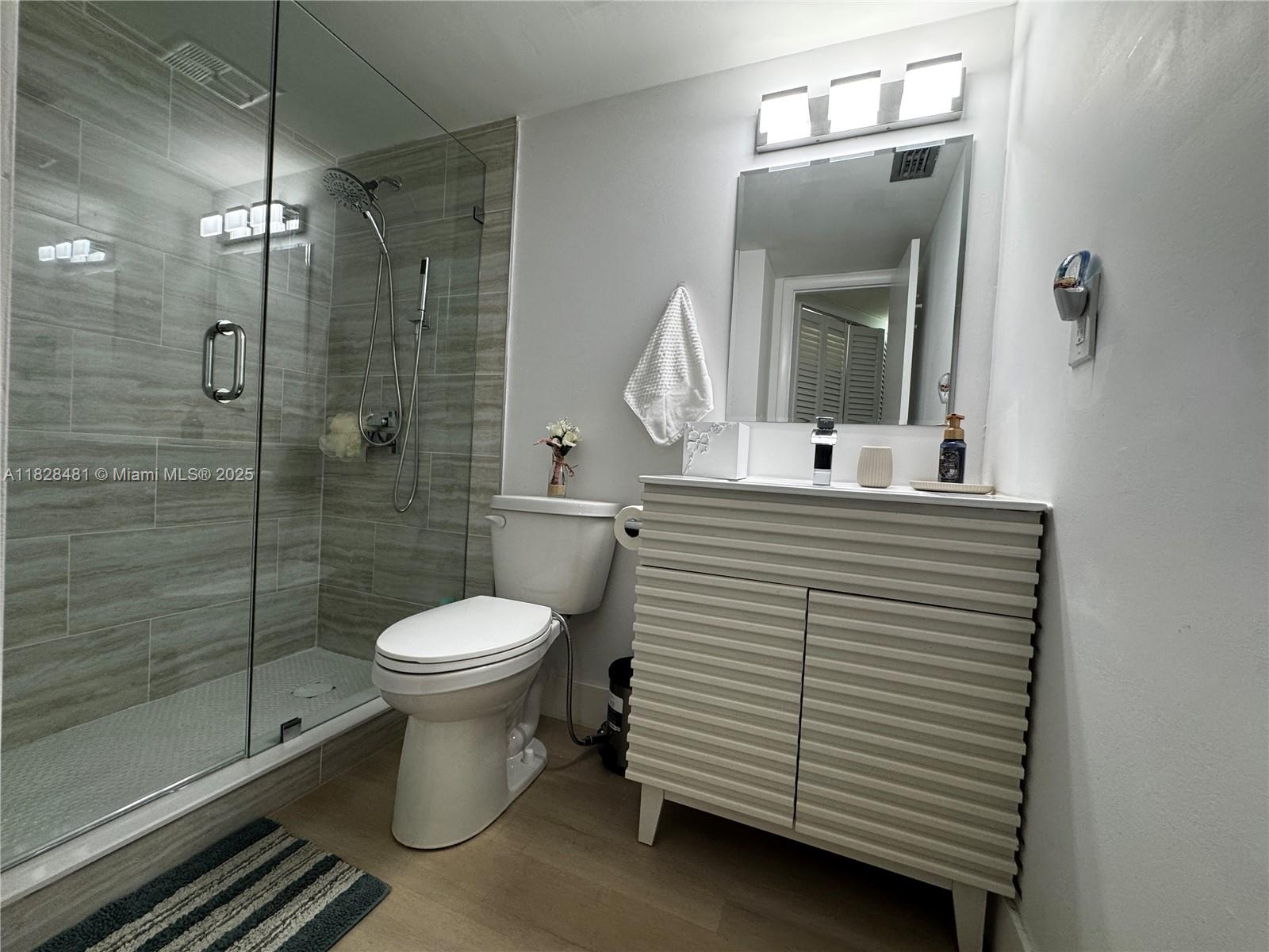 Step into this beautifully updated ground-floor 1-bedroom unit with direct garden access—perfect for enjoying the peaceful green garden views just outside your door. The interior features elegant, wide-plank NEW vinyl floors throughout and completely remodeled bathrooms with a walk-in rainfall shower and sleek modern tile. The bedroom offers dual closets, mirrored sliders, and ample natural light through large windows. Enjoy central A/C, Laundry Room, spacious living area, and a dedicated dining space adjacent to a bright, efficient kitchen. Unit also comes with a separate storage room. Located in a secure 55+ community with a low HOA, onsite amenities, and unbeatable convenience near shopping, dining, and major highways. Easy to show and ready to move in!