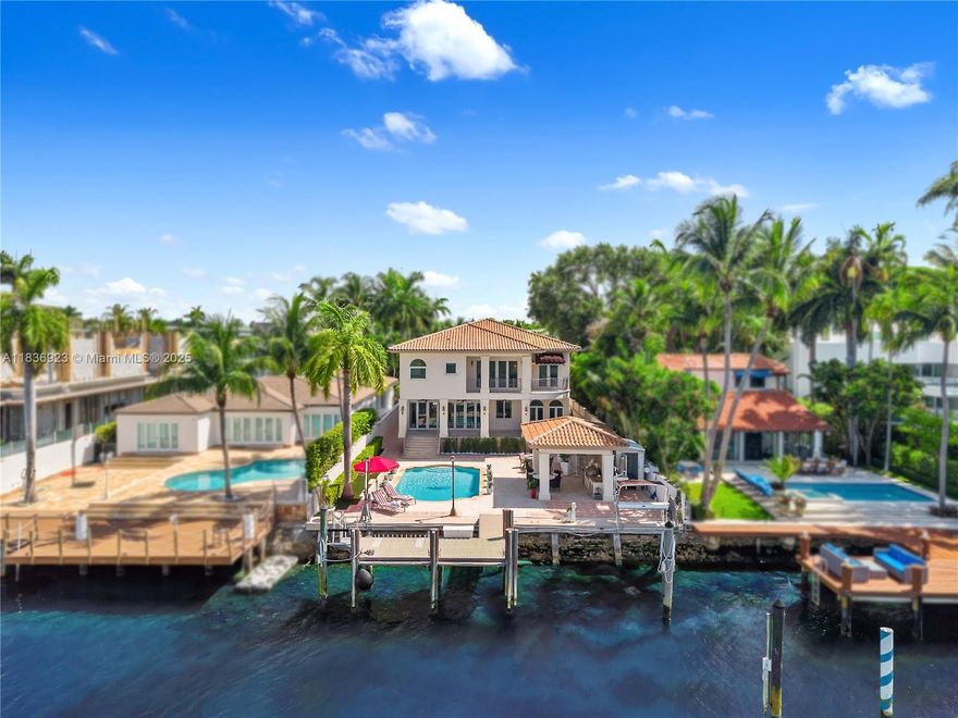 Nestled on prestigious Hibiscus Island, this 6 beds 5 baths Mediterranean waterfront home captures timeless elegance fused with resort-style living.  Step through the grand entryway into soaring high ceilings, a sweeping staircase, exceptional views of the water and your private oasis. Architectural details exude charm of a European seaside villa with arched and stone accents and spacious layout designed for entertaining and comfort. Features include a chef’s kitchen, grand primary suite with 2 balconies, elevator, summer kitchen and lush landscaping for privacy.  Perfectly positioned to capture expansive views of Star Island, Biscayne Bay and Miami skyline, the home sits on 60 feet of prime waterfront and includes a private dock.