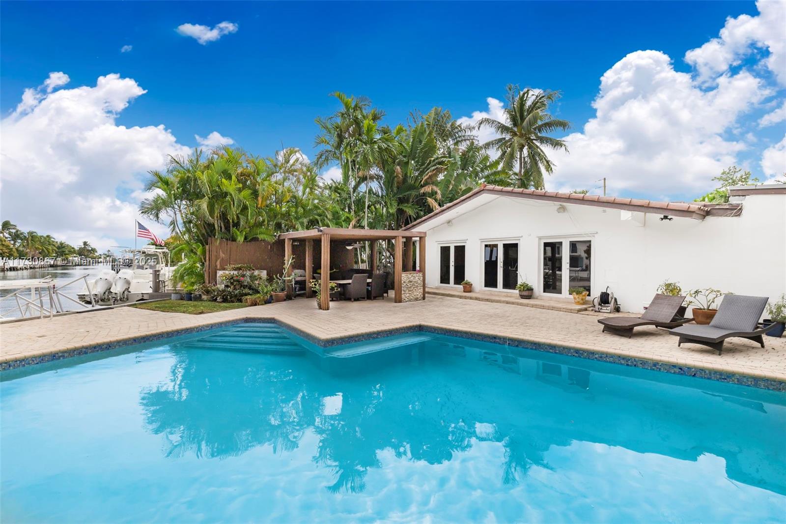 A boater’s paradise! This 3,000 sqft home boasts 4 bedrooms/ 4 baths plus office on a large 11,577 corner lot. The open floor plan has vaulted ceilings and sliding glass doors leading to the backyard, pool and dock. Waterfront living at its finest with a private dock and no fixed bridges to open bay. This property is conveniently situated in the gated community of Sans Souci Estates.