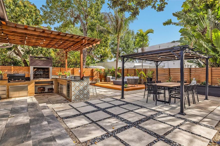 Open House! Sunday, April 12th, 2:00 PM - 4:00 PM. "EVERY DAY IS A HOLIDAY" living here!  Move-in ready! This comfortable and open living area features the updated kitchen with dramatic quartz counters as the HEART of this home! Lots of natural light pours through large impact glass doors.  An amazing 'knock-your-socks-off' outdoor kitchen and bar area also includes a large decked lounging area and trellis-covered outdoor dining area for 10! Inside the original hardwood floors throughout are inviting and add warmth.  There are 3 bedrooms in a ‘split plan’ and 2 new bathrooms.  Facing the private grassy yard area, the Primary bedroom has new built-in wall-to-wall custom closets, a charming bench, and an oversized en suite master bathroom with a huge glassed-in shower, and ample cabinetry in rich solid walnut wood and two basins.  An amazing ‘hidden jewel’ of a location, nestled on a cul-de-sac street just a stroll to some favorite schools and minutes from Miami Shores shops; Miami Beach causeways; Aventura, Brickell, Coral Gables and quick access to major highways.  Run don't walk!