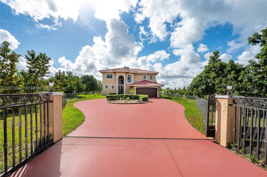 A Home That Welcomes, Inspires, and Comforts. Set on a 1.26-acre parcel in Miami’s Redland area, this distinctive two-story Mediterranean residence offers space, privacy, and a true indoor-outdoor lifestyle. The home features five bedrooms and three and a half bathrooms, with a thoughtful layout that balances open living areas and private retreats.

Upon entry, soaring ceilings and generous proportions define the main living spaces, creating a light-filled atmosphere ideal for both everyday living and entertaining. The kitchen anchors the home with ample workspace and flows naturally into the family area, overlooking the pool and outdoor entertaining spaces.

The upper level hosts multiple bedrooms, a dedicated laundry area, and a spacious primary suite complete with a large ensuite bath and walk-in closet. A ground-level bedroom provides flexibility for guests, extended family, or a home office.

Outdoors, the property transforms into a private retreat featuring a large swimming pool, expansive courtyard, shaded pergola, and a full tennis court—perfect for recreation or hosting gatherings. Mature fruit trees and lush landscaping surround the grounds, offering a tranquil setting rarely found within city limits.

This unique estate delivers the freedom of acreage living while remaining conveniently located, making it an exceptional opportunity for those seeking space, privacy, and versatility.