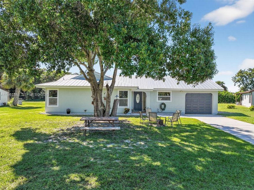 Updated home has total living space of 1780 sqft & sits on a spacious .32-acre lot with no swell, allowing easy access to the backyard—perfect for storing all your toys or adding a pool. Enjoy peace of mind with a brand-new metal roof and high-impact windows throughout. The front of the home faces Woodstorck Trail, with Hillmore Lake just across the street ideal for kayaking, nature watching and more right from your front yard. Additional features include underground power lines and placement on the hospital grid for added reliability. Conveniently located just minutes from shopping, dining, Hospital and downtown Jensen Beach, and only a 12-minute drive to the beautiful beaches. This home offers the perfect combination of modern updates, outdoor living, and an unbeatable location!