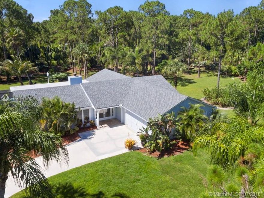 Price Reduced, bring offers!  Jupiter Farms home has it all ,2.3 acres of beautiful grounds with fruit trees, tropical foilage, ponds, bamboo and flowering shrubs includes a gated fence.  Home is  open concept. 4BR/2BA.  travertine marble floors in main area,
granite countertops, white cabinets and  newer appliances in kitchen as well.  2 bedrooms near  newly remodeled bathroom .  4th bedroom may be used as a den or office, it is off dining area. 
Diningrm, livingrm and master br all open with sliders to huge screened patio and view of 9' deep pool.   Very private setting.