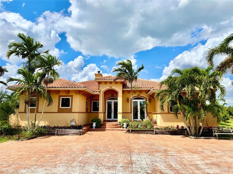 Welcome to Serenity Grove located in the highly sought-after Redlands agricultural area of Miami-Dade County, offering the perfect blend of serene country living & income-producing potential. This beautiful one-story ranch-style home sits on a thriving avocado grove and is enhanced by an array of tropical fruit trees, including guava, lychee, longan, mango, Jamaican cherry, and more, making it an ideal retreat for those seeking space, privacy, & agricultural income.

The home features a desirable split floor plan with soaring 15-foot ceilings, elegant marble & wood flooring, & impact-resistant windows and doors for added safety & efficiency. With two separate air conditioners & two heaters, the home ensures year-round comfort. Its inviting charm & spacious design make it perfect for both everyday living & entertaining.

A large 4-car carport provides abundant covered parking, complemented by an adjacent storage shed for tools & equipment. At the rear of the property sits a 1,200 sq ft galvanized steel workshop with 15 foot ceilings complete with a bathroom, second-floor loft, and two additional rooms. Previously used for storage, this structure can easily be converted into a guest house, office, studio, amazon warehouse, E-commerce center, car enthusiast or extra wellness space—offering tremendous flexibility and value.

Serenity Grove combines agricultural income, peaceful living, and investment potential in one exceptional offering. This is country living at its best!