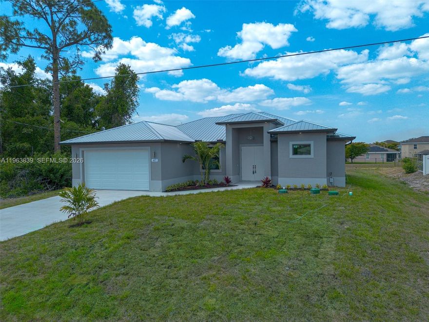 Welcome to this beautifully designed brand-new construction in prime Lehigh Acres. This 3-bedroom + den home
offers 1,717 sqft of living space on an oversized lot, blending comfort and modern style. The open-concept kitchen
features stainless steel appliances, flowing into spacious living areas with elegant porcelain floors. The master
suite includes two walk-in closets, a luxurious bathroom with dual showers, and a bathtub. Two additional
bedrooms and a den offer privacy and flexibility. A metal roof adds durability and style. Enjoy a 2-car garage and a
screened lanai with a full outdoor kitchen perfect for entertaining. A key highlight is the canal-front backyard,
offering privacy and Space. Disclosure: Some photos have been virtually staged to illustrate potential.