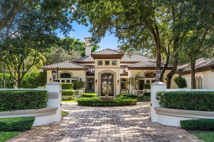 Elegant Mediterranean estate in the heart of Pinecrest on a sprawling 47,916 sq ft lot with 5,992 sq ft of living space. This 6-bedroom, 5.5-bath home features an open-concept layout with vaulted ceilings, wood-burning fireplace, and plantation shutters throughout. The gourmet kitchen, wet bar, and spacious living areas are perfect for entertaining. The primary suite offers his-and-hers vanities and custom built-in closets. Enjoy the outdoors with a beautiful pool, gazebo, and lush landscaping. A circular driveway with fountain and 3-car carport complete this exceptional property with a brand-new roof and completely repainted, designed for luxury and comfort.