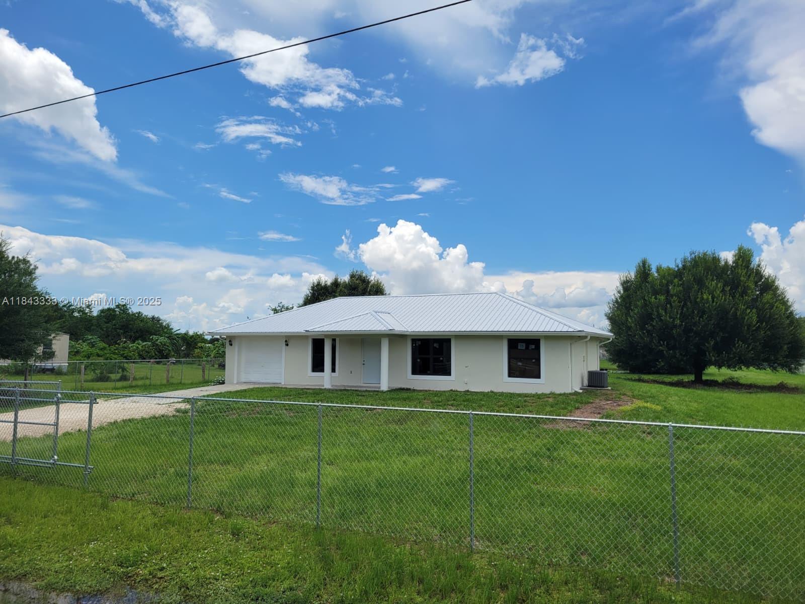 Single family home COMPLETELY REMODELED!! NEW 2025 Metal Roof - Windows- Fence all around property. The home features three bedrooms, two bathrooms, and the garage can be converted to an additional guest room. New appliances, renovated baths and Kitchen with quartz countertop !!!Don't miss out on this unique property!!!This peaceful community offers a quiet, rural feel while still being centrally located. This is a fantastic opportunity to own a beautiful home on 1.25 acres with a beautiful pond in Montura Ranch Estates, free from any association fees or restrictions. Located just one hour from Miami, this property offers a tranquil escape from the city's traffic, allowing you to enjoy the peace of a country community.
