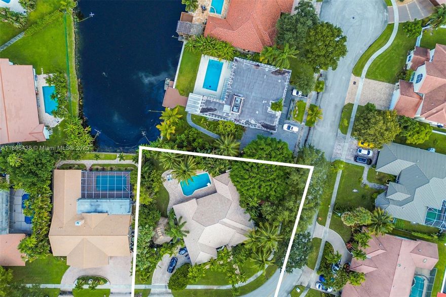 Beautifully updated 4 bedroom 2.5 bath home located in the highly desired Jacaranda community of Plantation on an oversized corner cul-de-sac lot w/ peaceful lake views. This elegant residence features travertine floors throughout the main living areas and engineered hardwood floors in 3 bedrooms + high ceilings  open layout w/ spacious living and dining areas. The gourmet kitchen offers 48" refrigerator double ovens large center island wine cooler, abundant cabinetry ideal for cooking & entertaining. The split floor plan provides privacy with a relaxing primary suite. Step outside to your private tropical retreat with covered patio tiki hut sparkling pool fenced yard half court basketball & lush landscaping creating the perfect outdoor lifestyle for family fun & entertaining on the water.