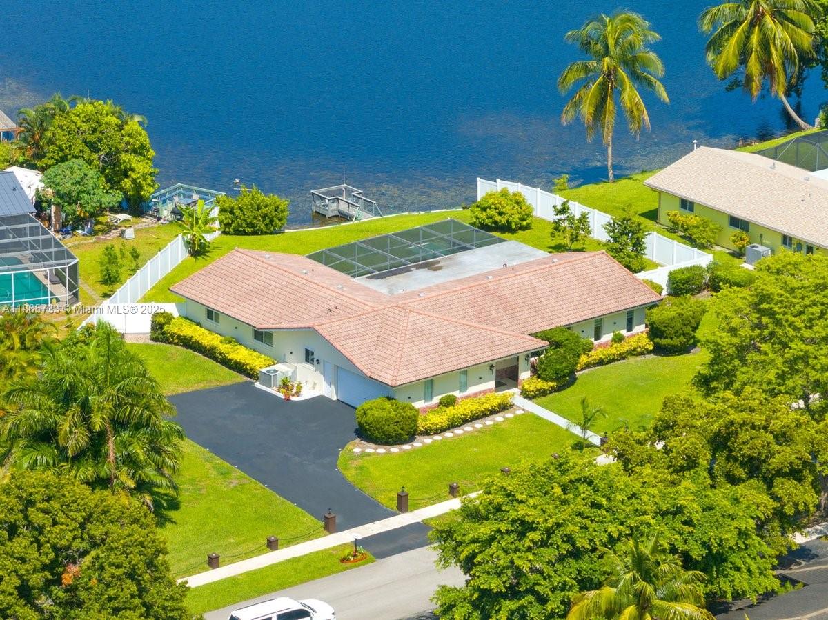 Welcome to your waterfront dream home in one of Plantation’s most sought-after neighborhoods! This stunning 4-bed, 2-bath pool home offers 2,600sqft of living space and sits on a rare, oversized corner lot. Step inside to bright, inviting open living areas with serene views of the lake. The home flows effortlessly from the living and family room and is remodeled throughout with modern finishes, including an updated kitchen with quartz countertops, and custom Italian cabinets. Complemented by upgraded bathrooms, tile flooring, COMPLETE hurricane impact windows/doors, Spanish tile roof. The backyard oasis features a pool, private dock, PVC fenced backyard and a variety of fruit trees. Minutes away from shopping, dining, parks & highways, this home is South Florida living at its best. NO HOA!