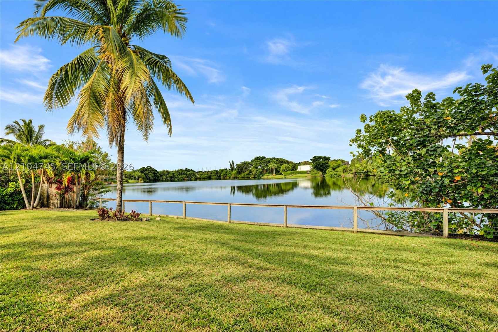 Open lawn sloping to the lake behind 1020 Bayberry Point Dr