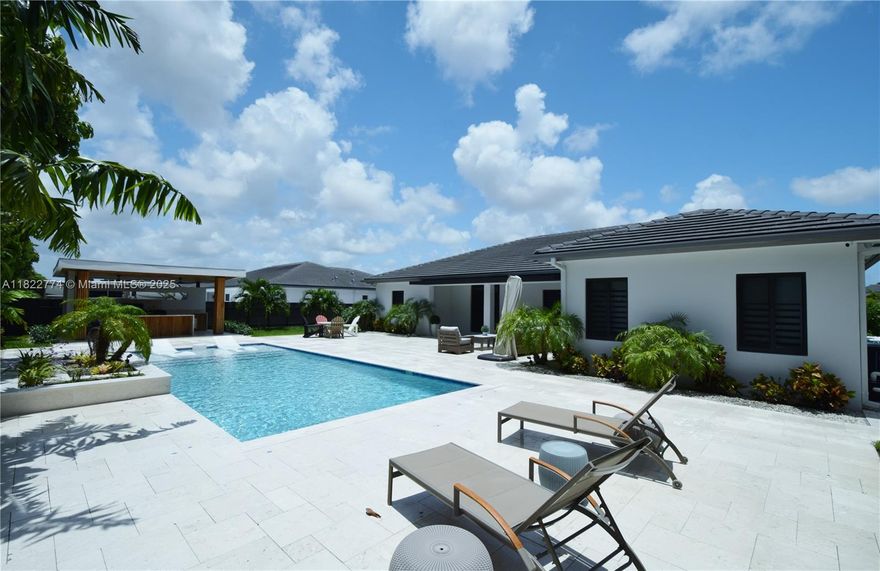 Step into this Meticulously fully upgraded home with all the bells and whistles with a resort style backyard perfect for entertaining. Everything Custom from Kitchen Cabinets, gorgeous Quartz countertops & Massive Island with built-in wine fridge and top of the line S/S appliances. Custom Designer Accented Walls, Doors, chandeliers, Walk-in Closets, Tray ceilings, and LED lighting throughout the house. 2 Car Garage with custom cabinets and a large lot with room for Boat and/or RV parking. Rear Patio features Travertine Tile with New pool and FULL outdoor kitchen complete with Gazebo, built-in grill, refrigerator, sink & island. Home Security System with Cameras and Impact Rated windows/doors, 5 mins from Turnpike and NO HOA