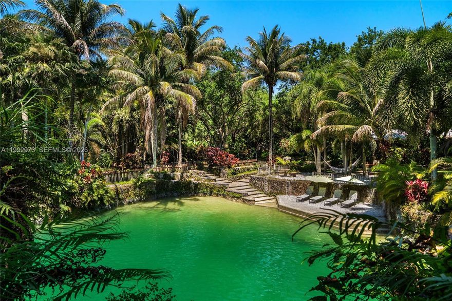 Breezy Oaks is a rare 14.38-acre tropical farm oasis in the Redlands featuring a private Florida Rock Pine Preserve. This one-of-a-kind sanctuary blends natural beauty, privacy, and endless potential. A dramatic entrance with massive coral rock pillars and custom copper gates leads to a winding coral rock-lined driveway and a 3BR/3BA surrounded by mature oaks and lush tropical landscaping. The property’s centerpiece is three freshwater coral rock grottos sourced from the Florida aquifer, masterfully crafted by renowned artisan Ben Bistrong. These extraordinary features include cascading waterfalls, sandy beach areas, a hidden cave, and tranquil swimming pools—creating a truly resort-like setting unlike anything else in South Florida. Expansive open lawns, winding paths, and a 3-acre rock pine preserve provide space for recreation, large-scale entertaining, or future customization and development. A thriving fruit grove with mango, avocado, and citrus trees, along with an on-site bee colony producing fresh honey, enhances the property’s organic, self-sustaining appeal. An elevated pad grass area for a 6-stall barn on the Southwest corner plus a substantial storage structure with dedicated access provides added utility and flexibility. Ideally located near the Florida Turnpike with easy access to Miami, Homestead, and the Florida Keys. An additional 29.20 acres are available for a combined 43.58-acre opportunity.