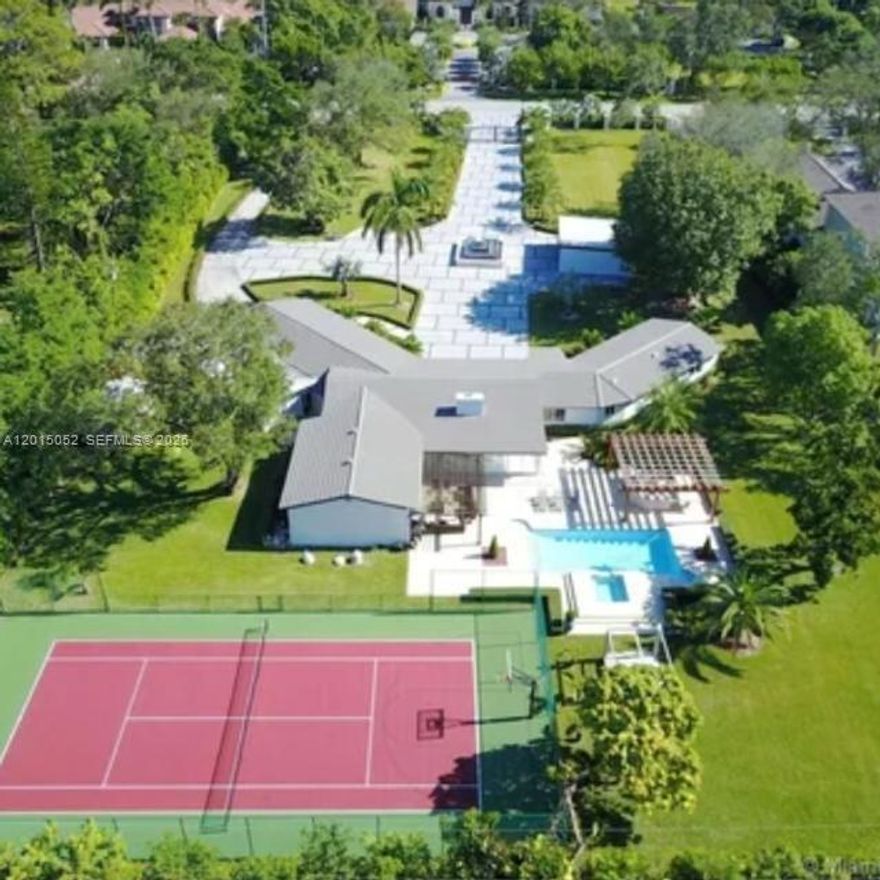 Occasionally, a property is so exquisite, so extraordinary, it stops you in your tracks. Your breath catches, your eyes widen, and for a moment, you are left in awe. This is that property.  Nestled on an exclusive gated 2-acre estate, centrally located, in the heart of South Miami, moments from Coral Gables, this magnificent smart residence offers privacy, elegance, and convenience, all controlled from your phone.  The home features five spacious bedrooms and four beautifully appointed bathrooms, including a cabana bath, plus a separate media room for intimate family evenings or sophisticated entertainment. Renovated in 2017, it showcases soaring vaulted ceilings and timeless sophistication throughout.  Two climate-controlled storage suites with electricity provide versatility and functionality. A two-car garage complements the expansive grounds, which also offer parking for up to 50 vehicles, along with a dedicated service entrance.  Outdoors, the estate transforms into a private resort oasis with a saltwater heated pool and jacuzzi, a fully equipped outdoor kitchen, and a covered terrace designed for elegant gatherings under the Miami sky.  The property also boasts private tennis and pickle-ball courts, lush tropical landscaping, a stunning Tiki Hut, and luxurious details throughout. This is more than a home; it is a sanctuary tucked within one of Miami’s most desirable neighborhoods.  Adding to its exceptional value, the expansive grounds offer subdivision potential, creating a rare opportunity for developers, investors, or families seeking to build an additional residence while preserving the estate’s privacy and grandeur. A rare masterpiece!