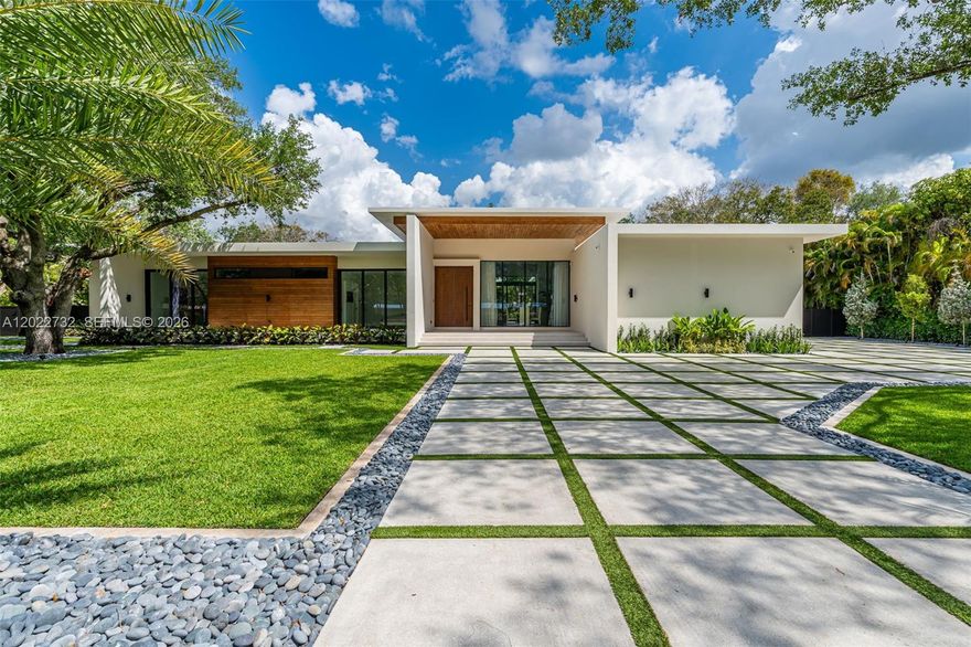 Built with exceptional durability and craftsmanship, this impressive residence offers 8,293 total square feet of solid concrete construction, including 5,349 square feet under A/C. Designed for both comfort and functionality, the home features 6 spacious bedrooms and 6.5 bathrooms, highlighted by a seamlessly incorporated 1-bedroom, 1-bath guest suite complete with dual walk-in closets. A striking 11-foot hurricane-impact mahogany pivot entry door welcomes you into expansive interiors showcasing soaring ceilings, abundant natural light, impact windows and doors, and refined finishes throughout. The gourmet kitchen is thoughtfully designed with premium Italian cabinetry, quartz countertops, and top-tier built-in appliances. Every ensuite bedroom enjoys serene views and direct access to the pool or outdoor living spaces. The luxurious primary suite elevates everyday living with a theater-quality 4K projector and oversized screen, creating a private cinematic retreat. Fully integrated smart home technology enhances convenience throughout.