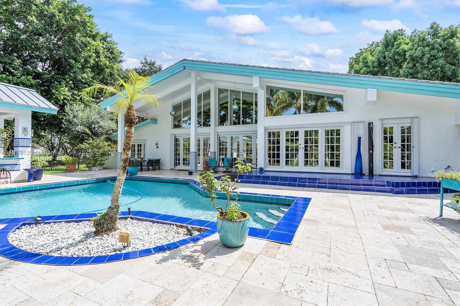 Welcome to Plantation! Behind the gates of Coco Plum Estates and set along the golf course, this residence offers 24/7 manned security and privacy on the community's largest lot over half an acre. This 5-bed, 3.5-bath home set on a lush oasis offers light-filled spaces, and convenience close to highways, airports, and top schools. The living room features soaring ceilings and a custom 9-foot chandelier, while the open kitchen boasts a 14-foot island with a 6-burner gas range. This home is hurricane-proof with impact windows, reinforced doors, and shutters for peace of mind during storm season. With new dual-zone AC units, a pool-view primary suite, and expansive patios—including a covered bar—it seamlessly blends indoor and outdoor living ready to be enjoyed with friends and family.