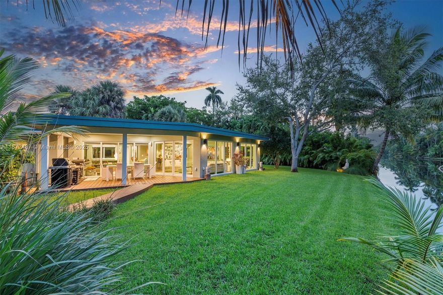 Step into a tropical waterfront sanctuary where every detail inspires serenity and connection with nature. This fully renovated property offers 4 bedrooms and 4.5 bathrooms total — 3 bedrooms and 3.5 baths in the main house, including 2 primary suites, plus a private guest studio with a full bath. An open living/dining area and designer kitchen create an inviting interior, while the detached studio provides flexible space for guests, work, or creativity. Outdoor living shines with a covered porch and tiki hut, complete with soaring ceilings, fans, and a bar. Lush landscaping attracts local birds, with room to add a pool. The property is fully fenced, with ample parking and two gated entrances for added privacy and ease. Just steps from MCDS.