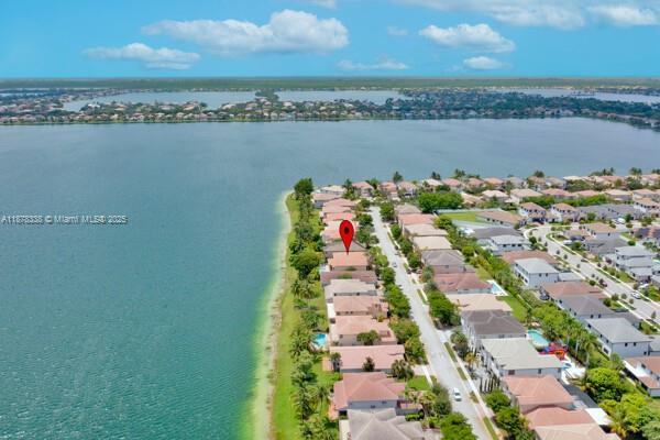 This stunning property offers the perfect blend of luxury and comfort, featuring beautiful and massive LAKE VIEW and POOL. It has new IMPACT WINDOWS and DOORS, elegant iron/wood staircase adds a touch of sophistication to the interior, while high ceilings and wood and tiles floors throughout the home amplify its spacious feel. Abundant natural light.The kitchen and family area seamlessly flow into the formal dining /living rooms. Downstairs, find a bed and complete bath,as well as a laundry room w/sink .Upstairs, the principal bed features a sitting area with amazing lake views.Two walk-in closets, and his/her bathrooms offer convenience.There are two more beds with a Jack and Jill bath.2-car garage /storage. This home combines elegance, functionality.GREAT LOCATION.TOP RANKED SCHOOLS