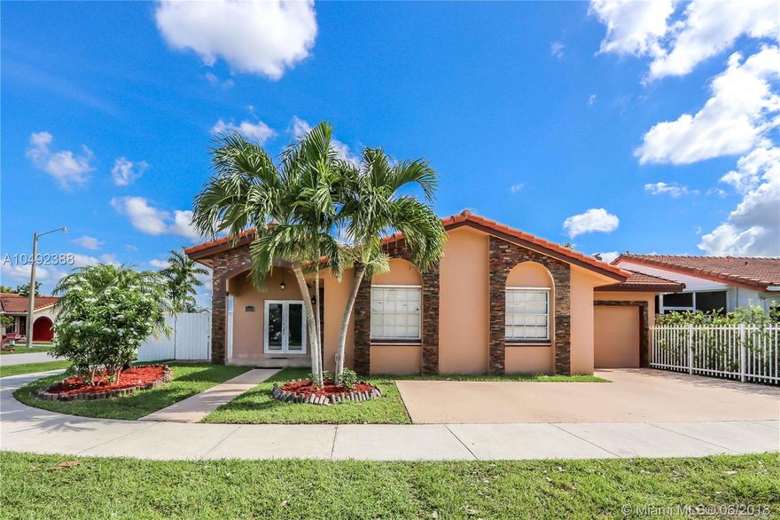 This corner family home features a California Style stone facade, high ceilings and lots of light.  Impact double door entrance opens up to a nice and spacious floor plan.  This property features 4 bedrooms and 3 baths with tons of extras! Tile floor throughout, one new remodeled bath with marble, customized walk-in closets, custom made kitchen with countertop Spanish tile, lots of cabinets for extra storage, and separate laundry room.  The covered terrace has new tile floor and a fan for your comfort.  Property is fenced with a new Durafence for privacy and security.  Garage has been converted to an office/den, but can be easily converted back.  Close to metro zoo, new developments, supermarkets and schools. This is the home to enjoy with your family. NO association