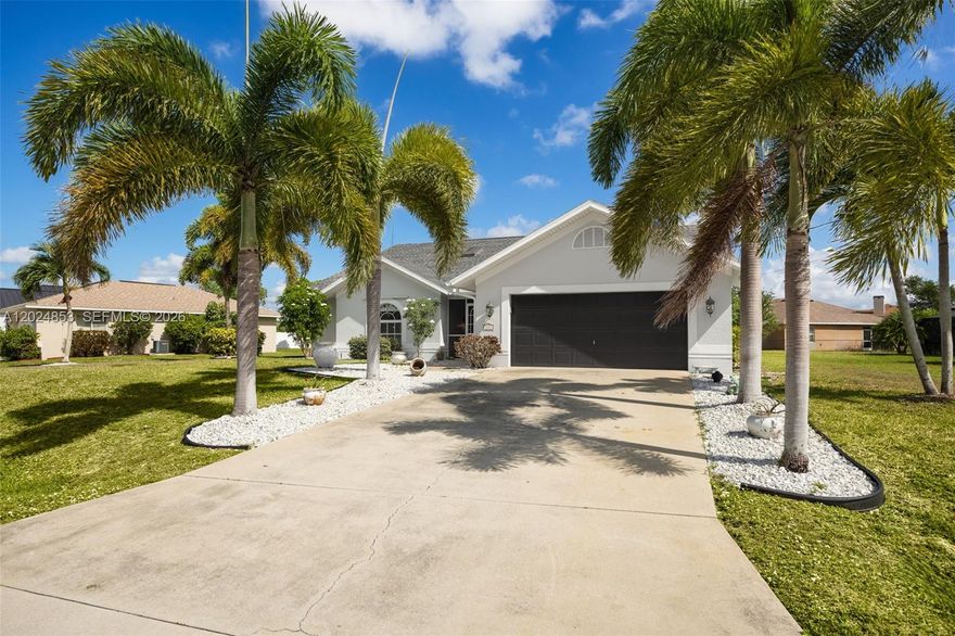 Located in SE Cape Coral, this centrally located home offers easy access to Fort Myers via the Midpoint Bridge and is under one mile from The Shops at Midpoint Center for shopping and dining. Cape Coral High School is also nearby, making this a convenient location. Tucked into a quiet established neighborhood, the home offers curb appeal with mature landscaping and tall palms lining the driveway. Inside, you’ll find soaring ceilings, natural light, and tile flooring throughout main living areas. The kitchen features updated stainless steel appliances, ample storage, and a functional layout. The split-bedroom floor plan provides privacy, with a large primary suite featuring his-and-hers closets and a spacious bathroom with room to update. The screened lanai connects from the living room, dining room, and primary suite for easy indoor-outdoor flow. The backyard includes mango and avocado trees and room for a pool. Updates include a 2023 roof, 2024 water heater, and newer appliances. The home is not in a flood zone. With space, a thoughtful layout, and a central SE Cape Coral location, this is a great opportunity. It is less than one mile from The Shops at Midpoint Center and Cape Coral High School is just around the corner. The home also features great curb appeal with mature landscaping and tall palm trees lining both sides of the driveway, plenty of natural light throughout. Backyard offers a true Southwest Florida feel with additional future potential at this price point.