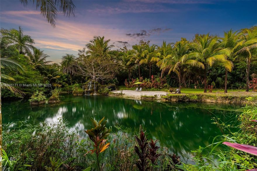 Welcome to Breezy Oaks, Miami’s hidden paradise—nearly fifteen acres of untouched beauty just moments from the city. This extraordinary property feels alive, where nature and art coexist in perfect harmony. Three crystal-clear grottos designed by coral artist Ben Bistrong shimmer with fish from the Floridian aquifer, surrounded by rare and endangered plant species, twisted trees sculpted by time, and vibrant wildlife. The three-bedroom farmhouse rests among flourishing gardens and countless fruit trees, creating an environment unlike anywhere else in South Florida. Whether envisioned as a luxury retreat, an equestrian sanctuary, or a generational estate, Breezy Oaks is a masterpiece of nature’s design—an oasis that simply cannot be replicated.