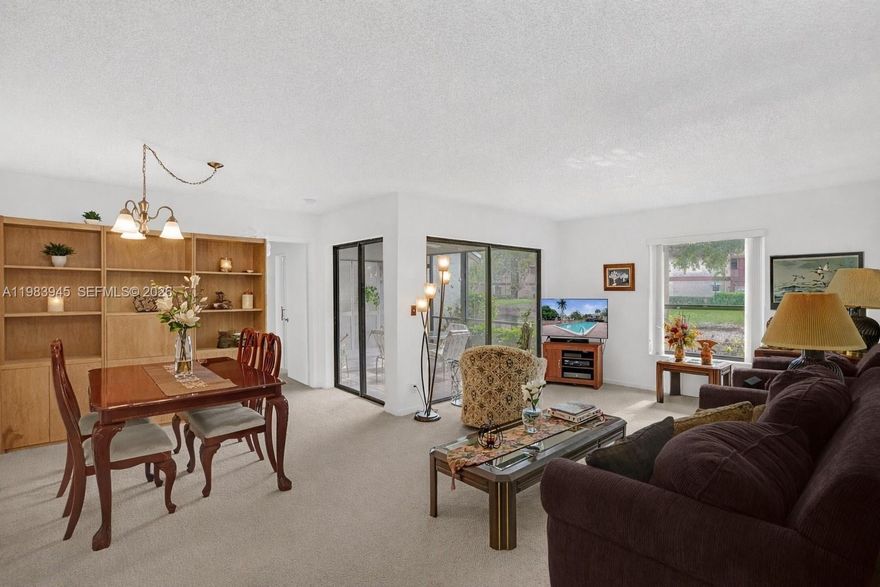 Spacious first floor corner residence overlooking a peaceful pond. This bright home is filled with natural light from numerous windows and features an open living and dining area that flows seamlessly to a screened patio, perfect for enjoying the water views. The primary bedroom offers a large walk in closet, and the unit includes a convenient in unit washer and dryer. The condo has been impeccably maintained in its original condition, giving a new owner the opportunity to update and design the space to their personal style. This condo community is part of the The Township at Coconut Creek, offering many amenities, including a clubhouse, performing arts theater, fitness center, aquatic center, olympic style pool, sports park, tennis courts, racquetball courts, billiards, and scenic walking paths. Conveniently located near shopping, dining, parks, and major roadways.