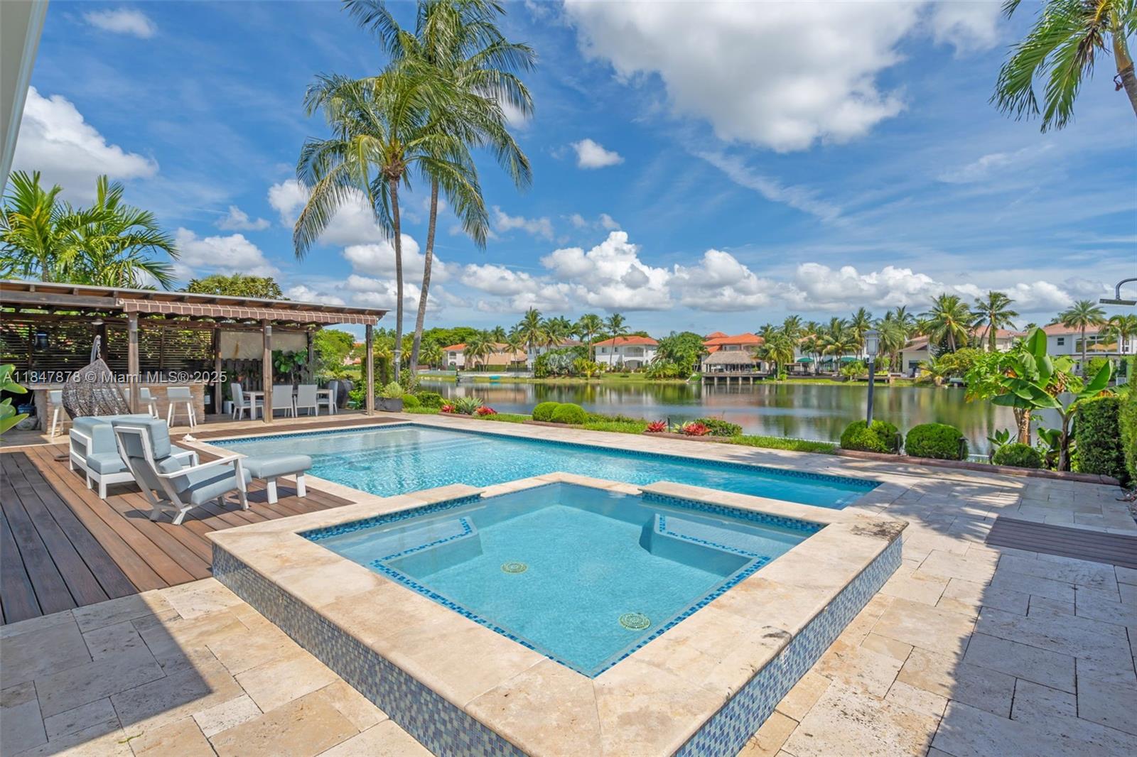 Turnkey ready in Riviera at Doral Isles! This fully remodeled 4-bedroom + den, 3-bath home offers breathtaking lake views, a heated pool with spa, and a complete outdoor kitchen/wet bar. Enjoy all impact doors and windows, Italian porcelain floors, a chef’s kitchen with top-tier appliances & induction cooktop, updated bathrooms, electric blinds, retractable awnings, and a full-home water filtration system. New A/C units, upgraded pool equipment, and new roof completed March 2025.